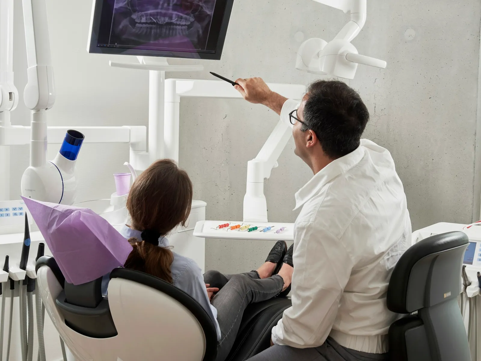 Dentist reviewing notes during a consultation