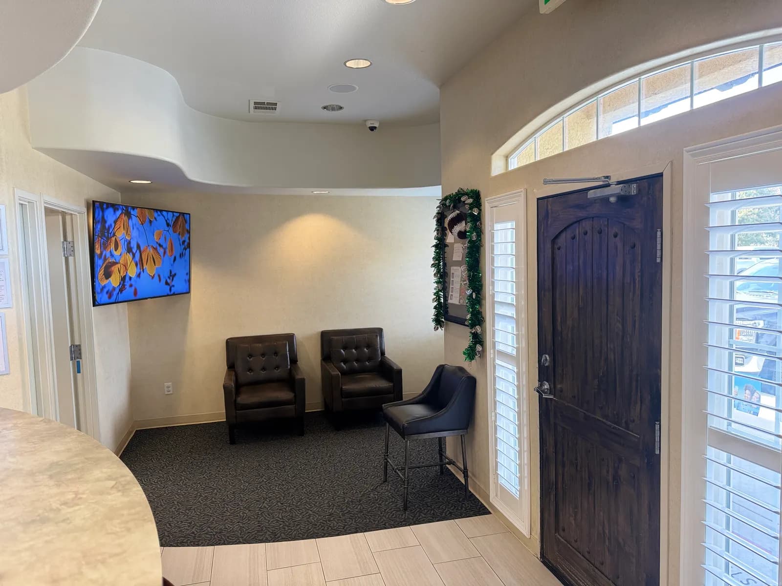 Reception area at Navarro Dentistry with leather chairs and a wood door