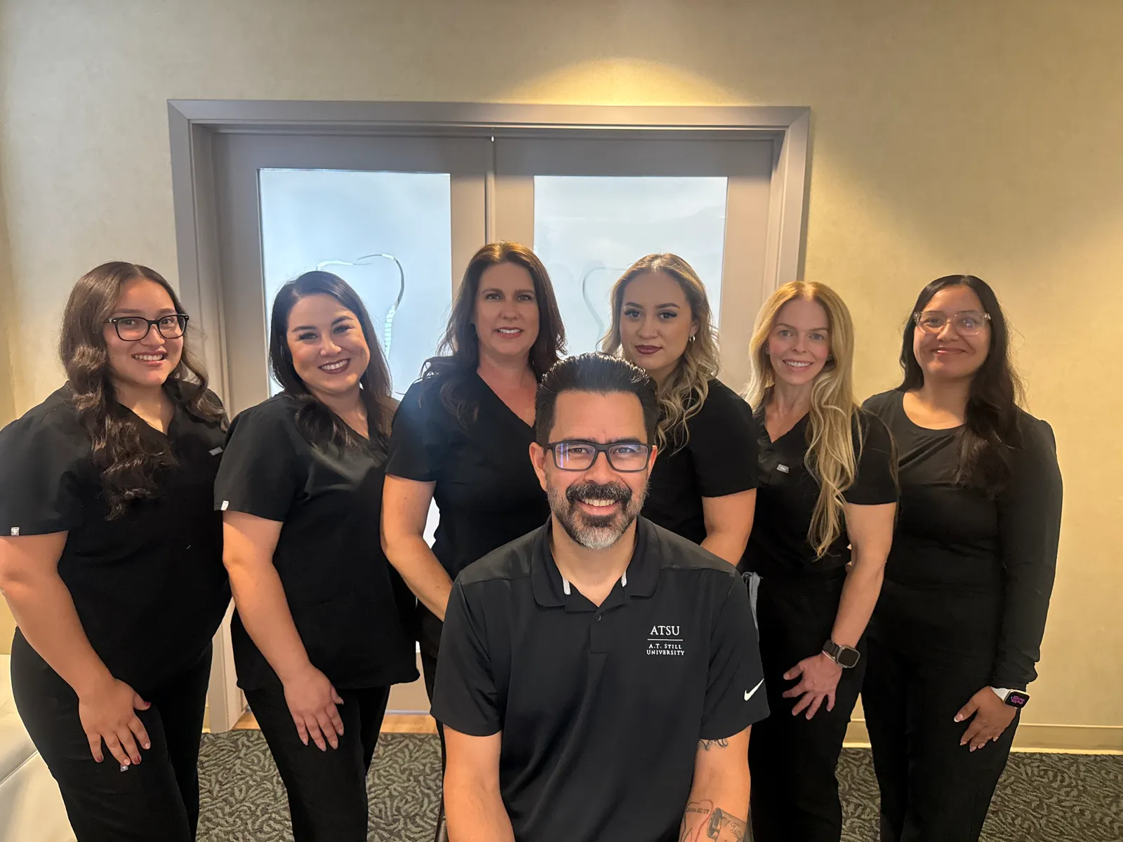 Dr. Isaac Navarro standing with members of the Navarro Dentistry team inside the office