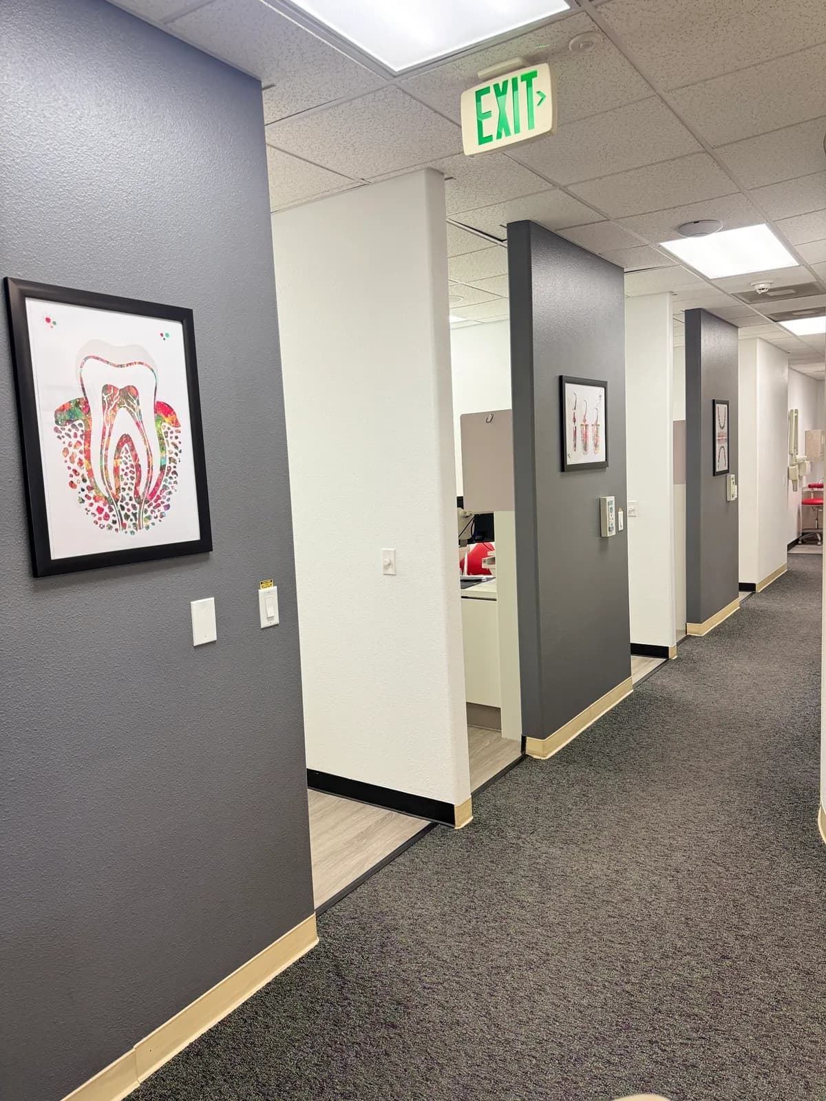 Hallway outside the treatment rooms at Navarro Dentistry with framed tooth artwork